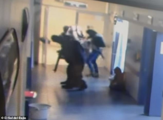 One of the men is seen shoving the terrified security guard to the ground, before the gunmen flee the hospital