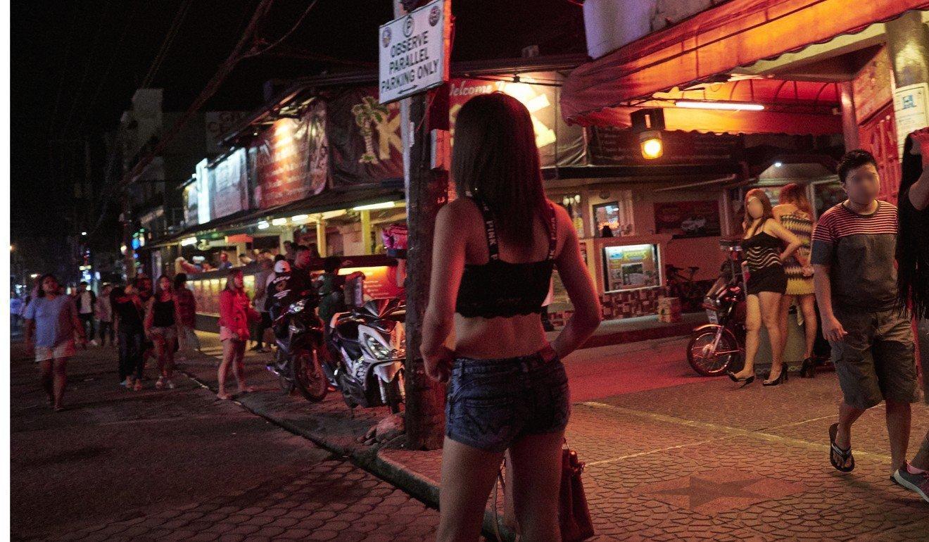 A young woman is seen walking on Fields Avenue - a pedestrianised street in Angeles City's red light district. Photo: Francesco Brembati