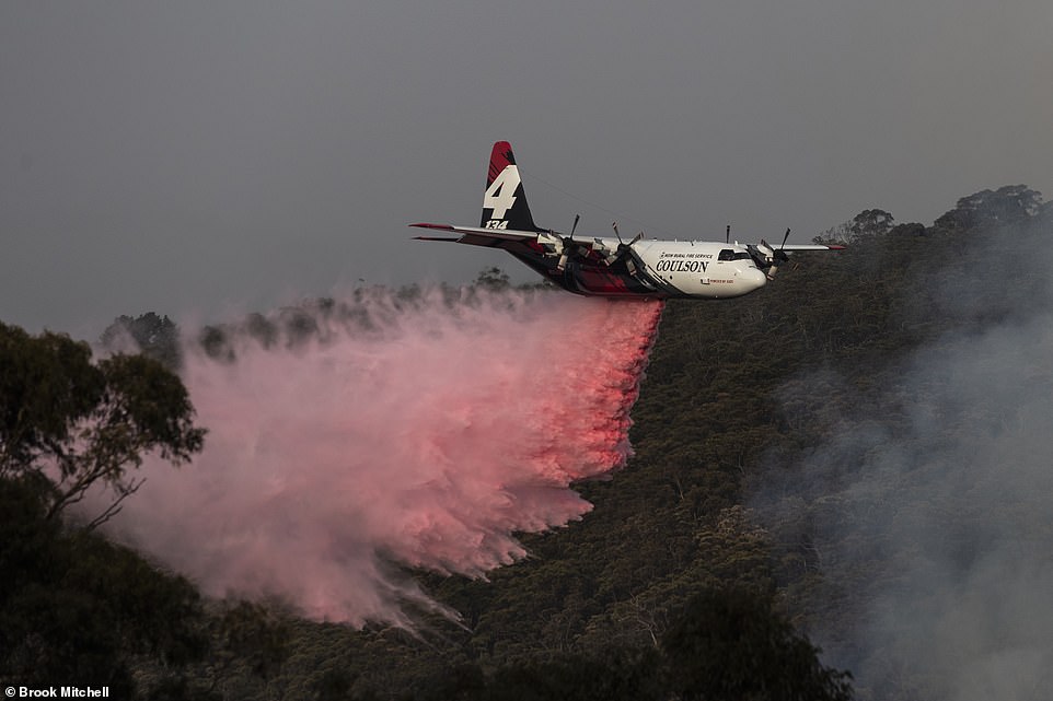 A large air tanker drops retardant near a property today in Penrose, Australia