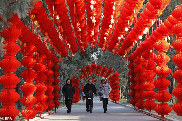 People walk through a tunnel decorated with red lanterns at Ditan Park on Tuesday